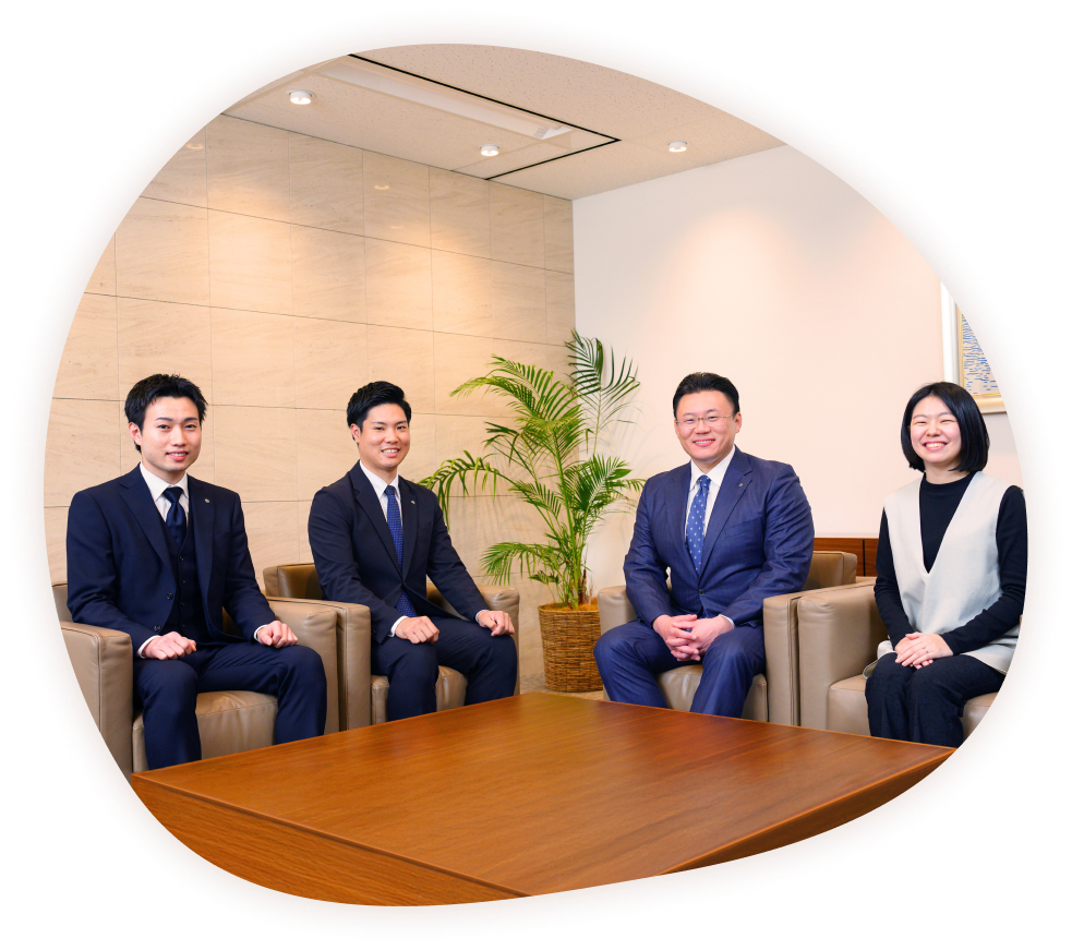 応接室のソファに座って微笑む4人の写真