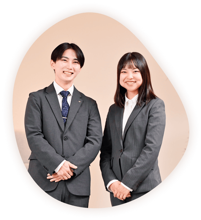 さわやかに笑うスーツ姿の20代男女の写真