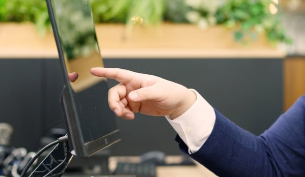 PCの画面を指差す男性の手の写真