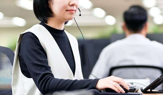 ヘッドセットをつけたPCの前に座る女性の写真